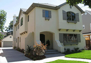 Angled view of a two-story home with a complex roofline and subtly curved adobe features