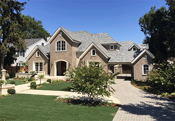 Front view of a large, two-story brick-and-stonework home with multiple gables
